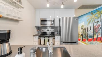 A modern kitchen with stainless steel appliances, a coffee machine, and a sink.