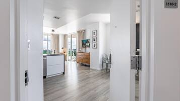Ein modernes Apartment mit Küche, Essbereich und einem Balkon mit Blick auf die Stadt.