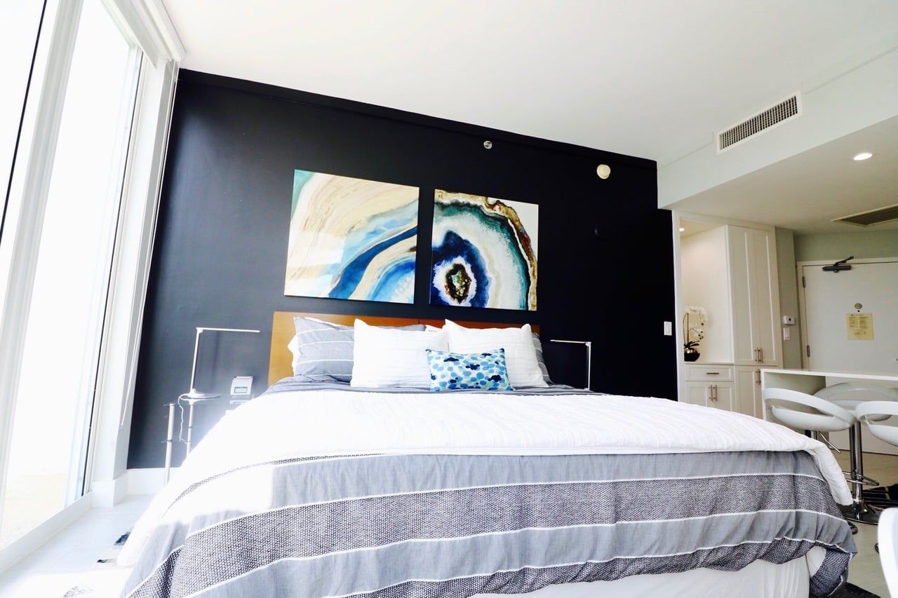 Una habitación de hotel con cama, escritorio y silla.