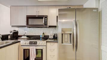 A modern kitchen with stainless steel appliances, including a microwave, refrigerator, and oven.