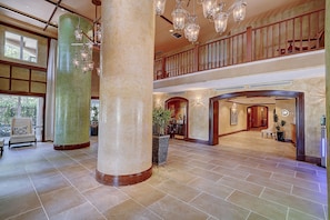 Eine geräumige Lobby mit hohen Decken, großen Säulen und einer imposanten Treppe.