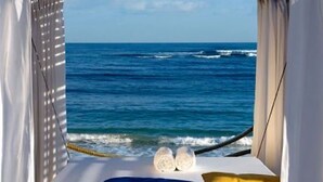 A bed with a view of the ocean, a rope, and two pillows. - 1BR VIP Residence Suites, All-Inclusive, Gold band, Puerto Plata, DR (Puerto Plata)