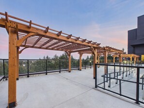 A wooden pergola structure on a rooftop terrace with a clear view of the surrounding landscape. - Scenic 3BR Mountain and Lake Haven in Bear Mountain (Langford)