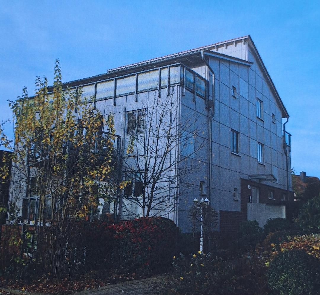Ein modernes Gebäude mit flachem Dach und großen Fenstern.