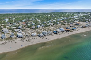 An aerial view of a coastal residential area with houses adjacent to a sandy beach and the ocean. - Private Beach · Heated Saltwater Pool · Ocean View (Gulf Shores)