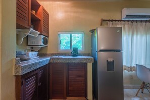 Eine kleine Küche mit Kühlschrank, Mikrowelle und Kaffeemaschine.