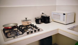 A kitchen with a gas stove, a pot, a pan, a microwave, and a toaster. - Cozy 1-bedroom apartment in fantastic Puerto Baquerizo Moreno with AC (Puerto Baquerizo Moreno)