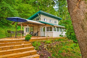 A two-story house with a porch, outdoor seating, and a staircase leading to the entrance. - Couples Delight, Pet Friendly, close to Brown County State Park! (Nashville)