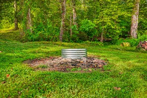 A metal structure in a grassy area surrounded by trees.