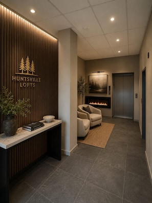 A modern reception area with a wooden panel wall, a fireplace, and a seating area.