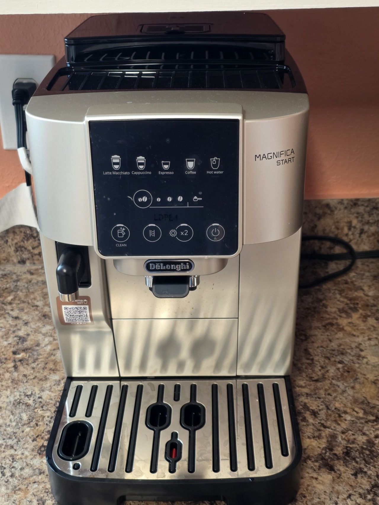 A coffee machine with a control panel, brand name, and a power cord.