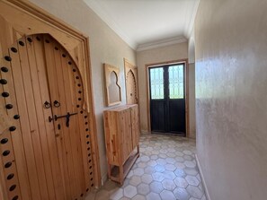 A hallway with wooden doors and a hexagonal tiled floor. - 3-bedroom, 3-bathroom house with a private pool—not overlooked—featuring a hammam and views of the Atlas Mountains (Marrakech-Safi)