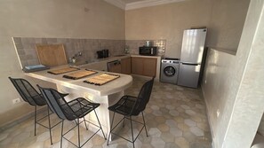 A compact kitchen with a central island, a washing machine, and a refrigerator. - 3-bedroom, 3-bathroom house with a private pool—not overlooked—featuring a hammam and views of the Atlas Mountains (Marrakech-Safi)