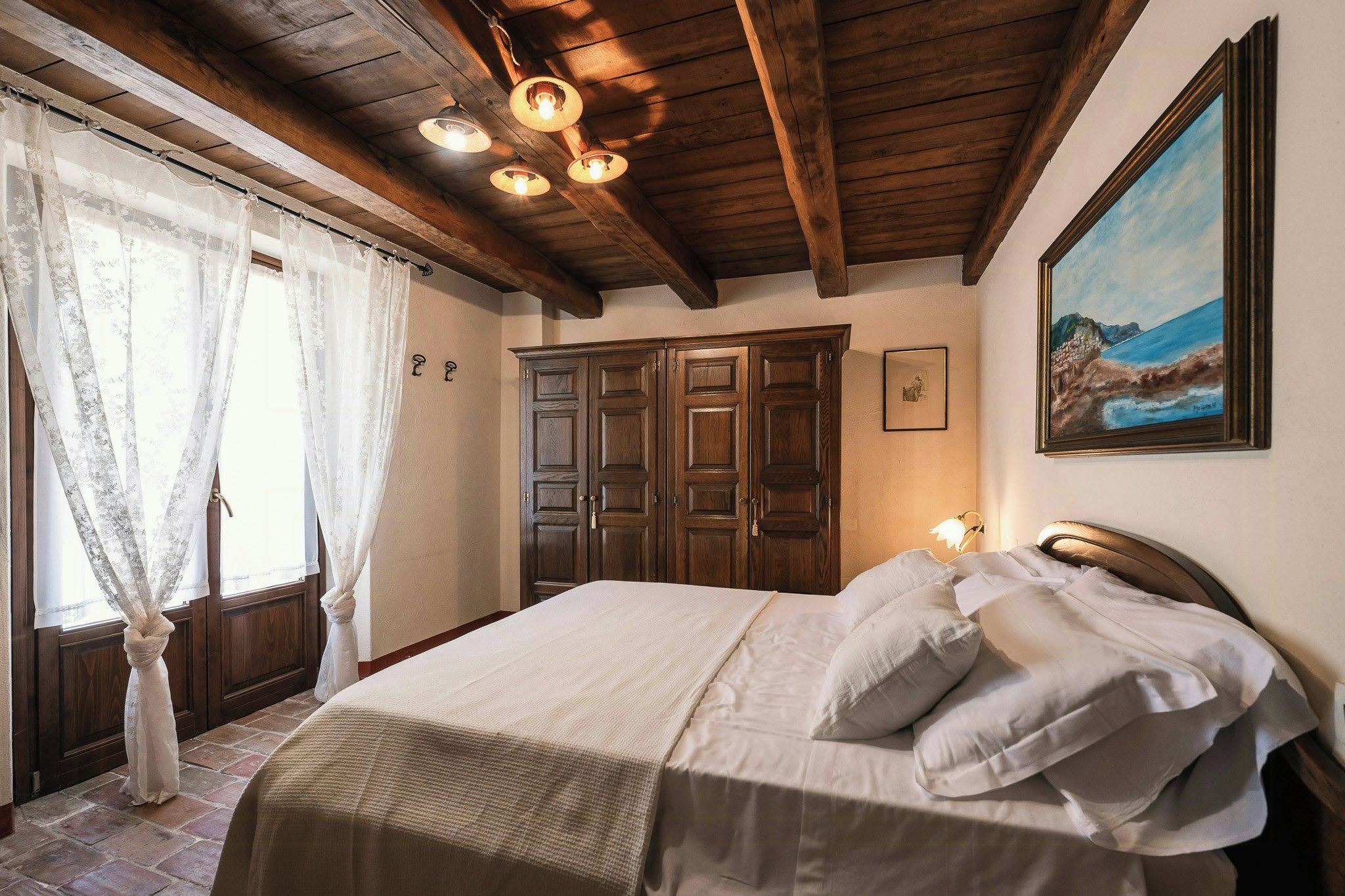 Ein Schlafzimmer mit einem Bett, einem Holzschrank und einem Bild an der Wand.