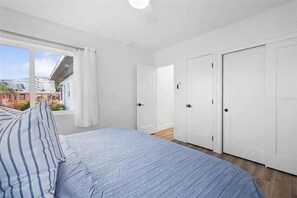 A bedroom with a bed, a window, and a door. - Steps to St. Pete Beach / Luxury Coastal Condo #4 (St. Pete Beach)