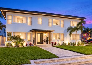 A two-story house with a front porch, multiple windows, and a well-maintained lawn. - Steps to St. Pete Beach / Luxury Coastal Condo #2 (St. Pete Beach)
