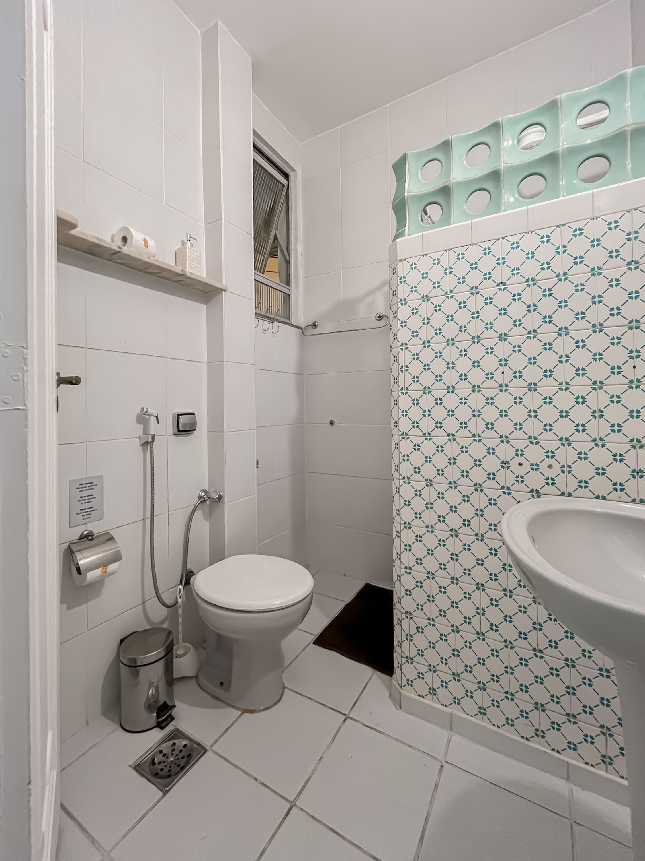 A bathroom with a toilet, a bidet, a sink, and a shower area.