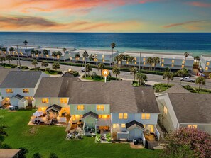 A coastal residential area with multiple two-story houses, a street with parked cars, and a view of the ocean. - Editorial Townhome on Quiet Beach • 3mi to 30A (Panama City Beach)
