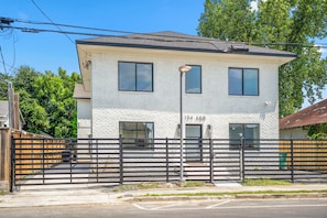 A two-story building with a brick facade, numbered 134 A&B, and a black metal fence in front.