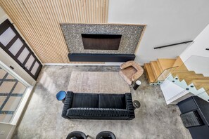 A modern interior with a black sofa, a wooden bench, and a fireplace.