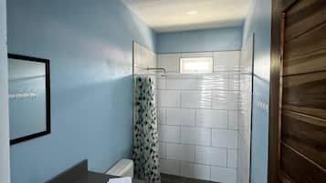 A compact bathroom with a bathtub, toilet, and shower area.