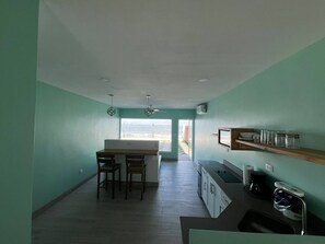 A compact kitchen with a dining area, a built-in oven, and a coffee maker.