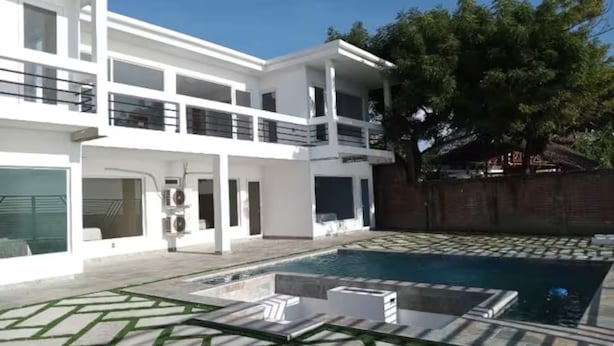 A modern two-story house with a swimming pool, outdoor seating, and a large tree in the background. - 7-bedroom Beach Front house in Play Miramar with AC (Miramar)