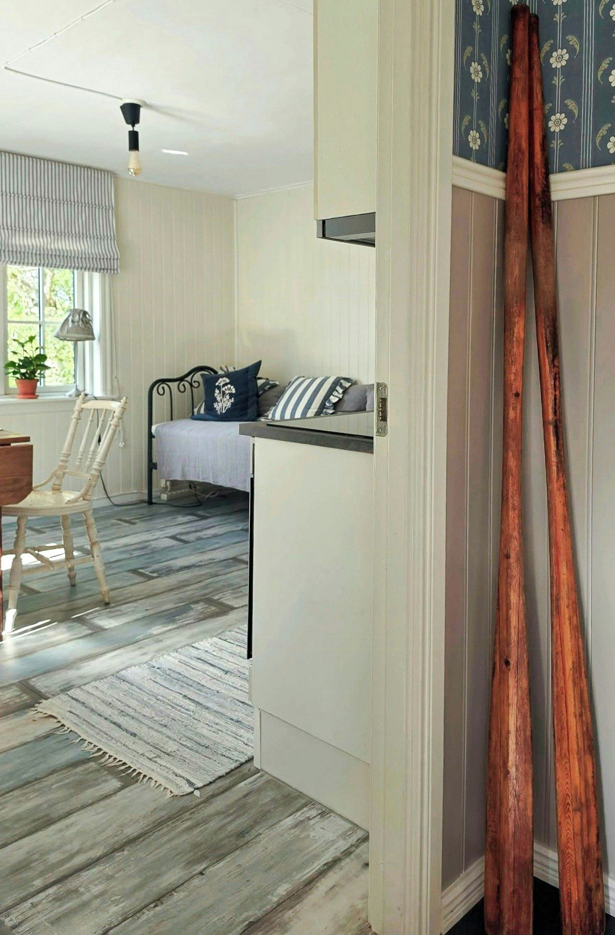 Une chambre avec un lit, un bureau, une chaise et une fenêtre donnant sur un paysage verdoyant.