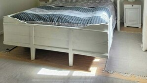 Ein Schlafzimmer mit einem Bett, Nachttischen, einem Deckenventilator und integrierten Regalen mit Büchern und Dekoration.