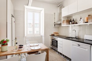 Eine moderne Küche mit weißen Schränken, einem Backofen und einem Geschirrspüler.