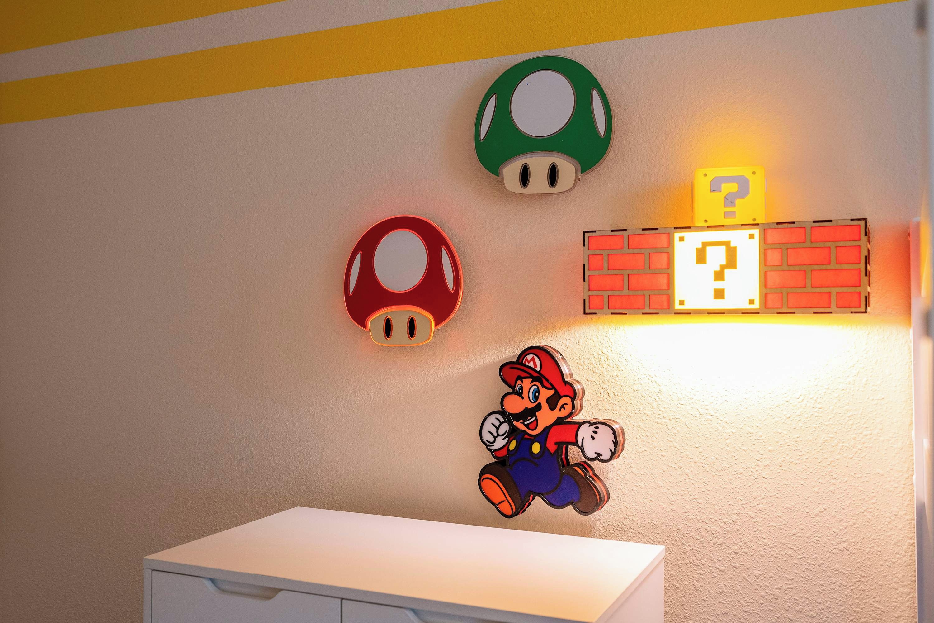 Una pared con recortes del personaje Mario y un cartel con signo de interrogación.