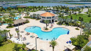 Ein Resort mit großem zentralen Pool, mehreren Gebäuden und einem See im Hintergrund.