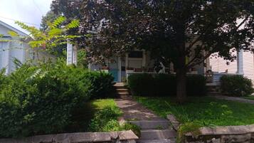 Un quartier résidentiel avec un chemin menant à une maison dotée d’un porche à l’avant.