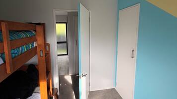 A room with bunk beds, a door, and a carpeted floor.