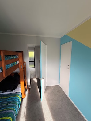 A room with bunk beds, a door, and a carpeted floor.