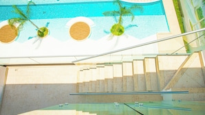 A modern interior with a glass staircase leading to a pool area. - Cana Rock  (Punta Cana)