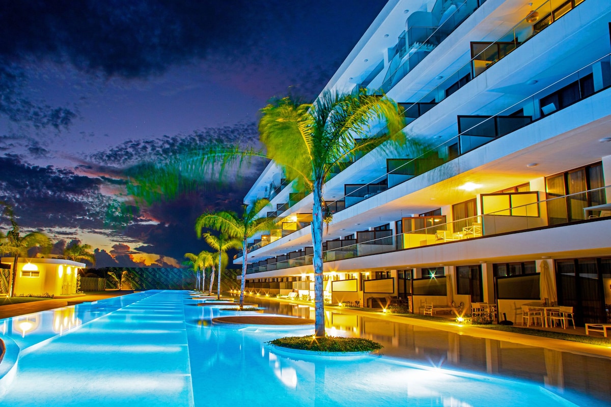 Ein modernes Hotel mit Schwimmbad, Palmen und Nachthimmel.