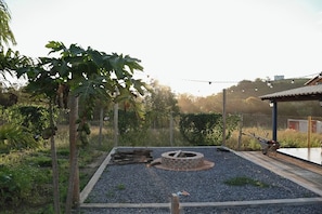 A garden with a circular brick structure, gravel paths, and a wooden fence.