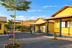 Un patio con edificios amarillos, un árbol y un camino de grava.