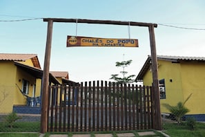 A wooden gate with a sign above it. - Chalés do Popô na Canastra (São Roque de Minas)
