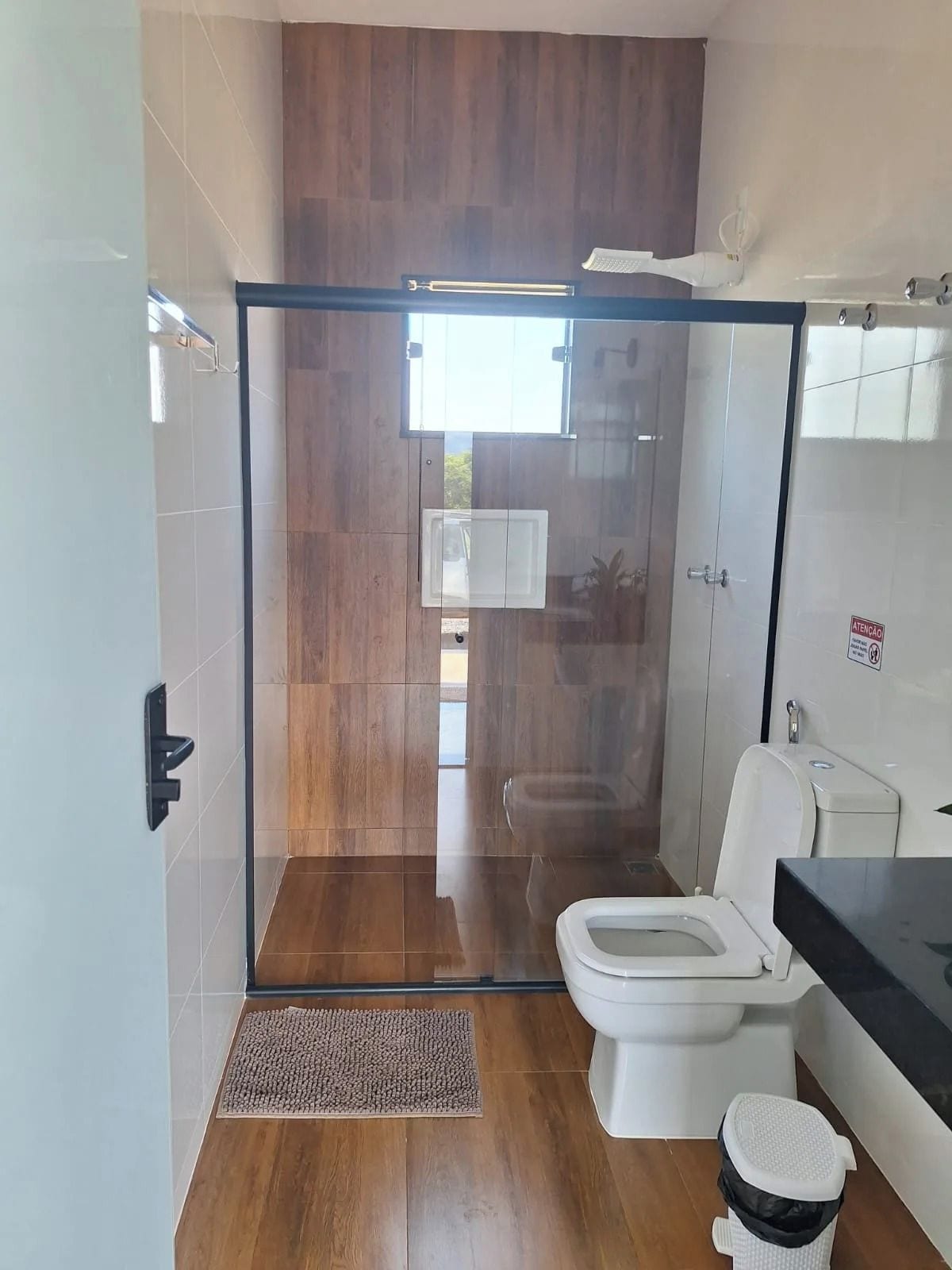 Une salle de bain moderne avec une douche à parois de verre, des toilettes et un lavabo.