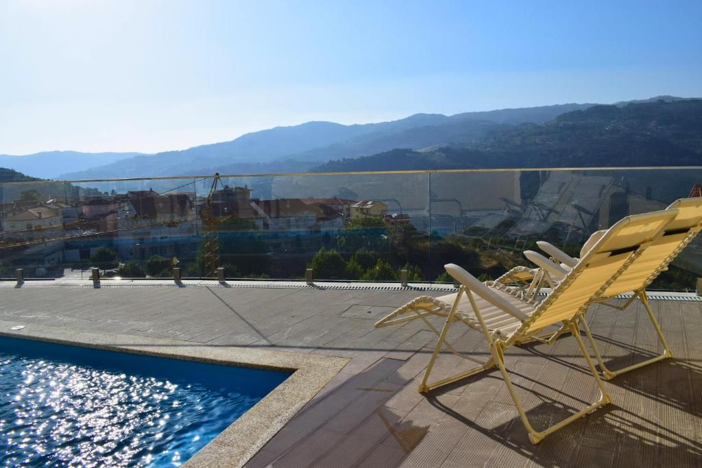 Un espace piscine aménagé sur le toit, avec des chaises longues et une vue sur le paysage environnant.