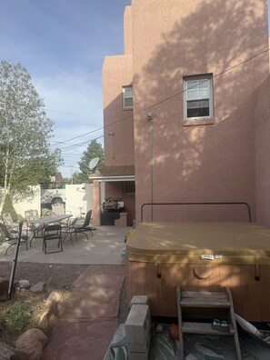 A patio with outdoor furniture, a hot tub, and a wooden ladder leading to a covered area. - Historic Fire Station # 4 apartment with AC in Pueblo (Pueblo)