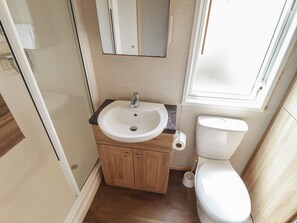 A compact bathroom with a sink, toilet, and a mirror. - Tattershall Lakes Country Park - Holiday Accommodation 16408 (Lincoln)