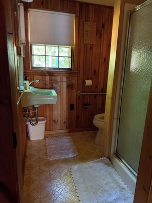 Un bagno in legno con lavandino, WC e finestra.