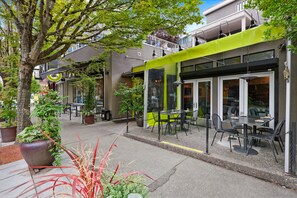 An outdoor cafe with tables and chairs, surrounded by potted plants and trees. - Private, stylish townhouse in Prime Capitol Hill, Seattle location (Seattle)