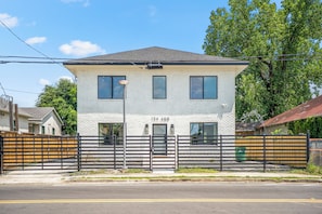 A two-story building with a white brick facade, numbered 134 A&B, and a black metal fence in front.