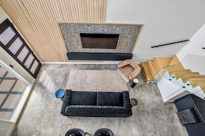 A modern interior with a black sofa, a wooden bench, and a fireplace.