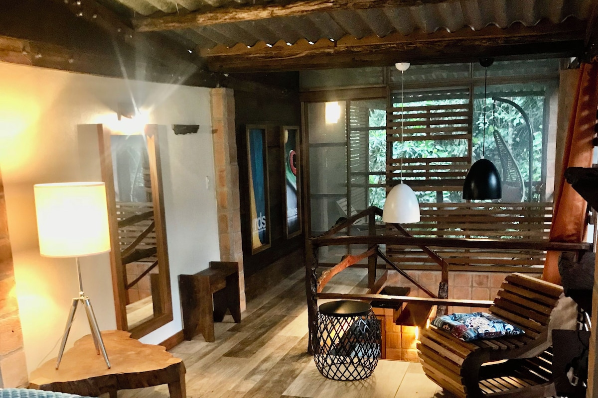A room with a bed, a desk, a chair, a lamp, and a window with blinds.