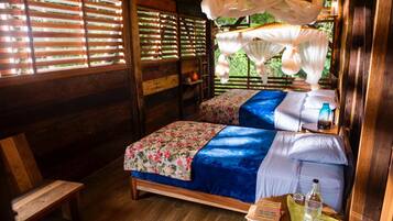 A wooden room with two beds, a bench, and a window with blinds.